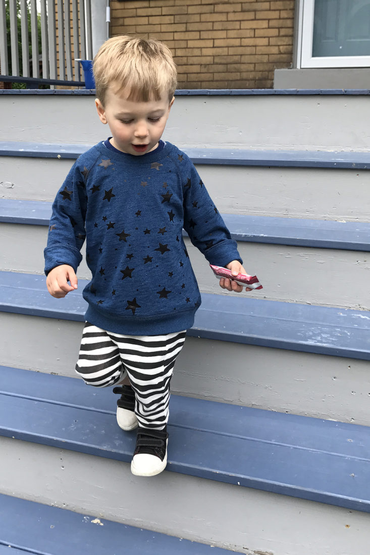 Toddler wearing blue sweatshirt and striped pants from Little Starters