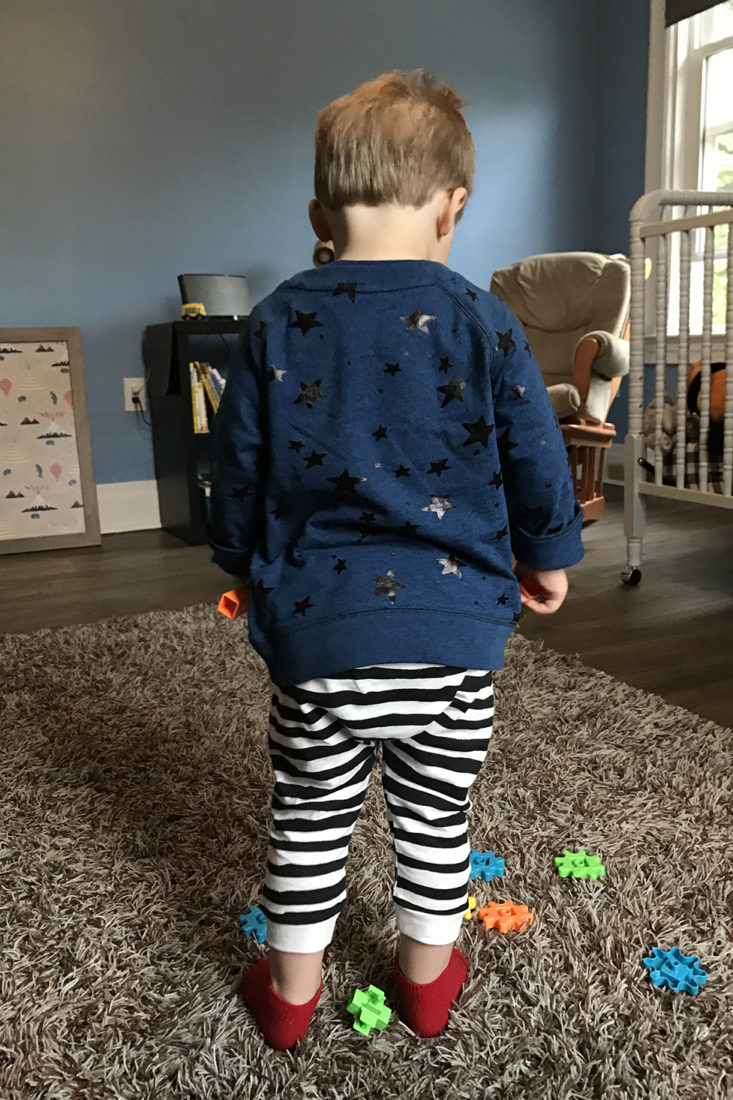 Toddler wearing blue sweatshirt and striped pants from Little Starters