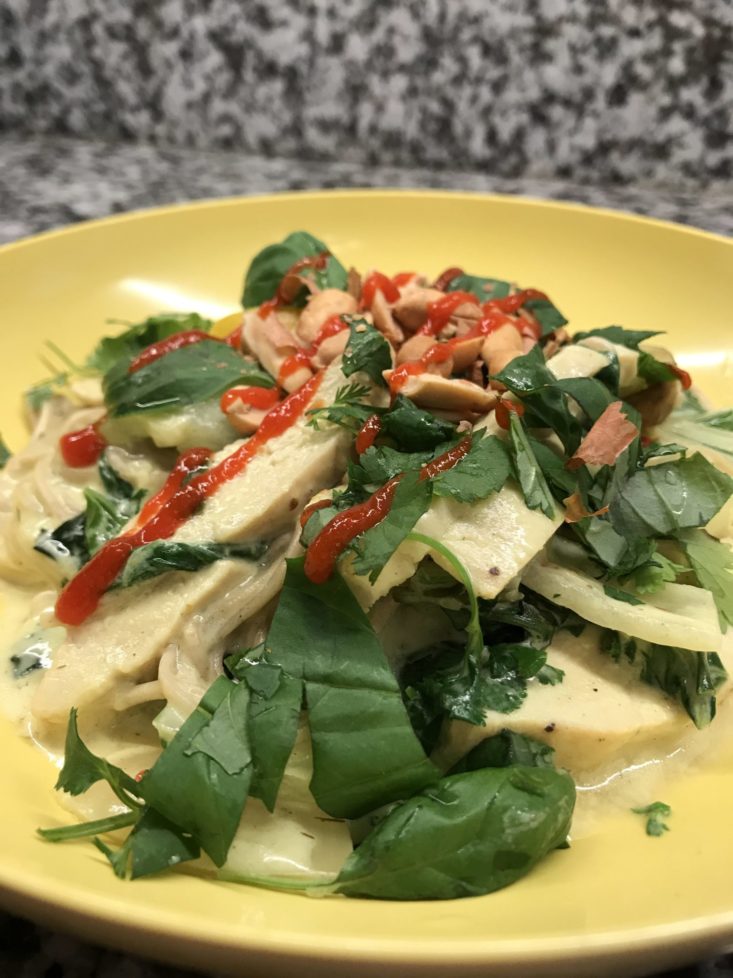 Completed meal of lemongrass curry with fresh cilantro and basil