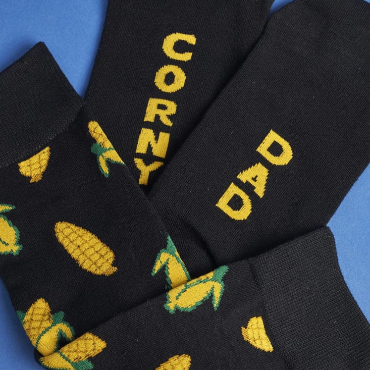 Detail of socks showing corn pattern and "Corny Dad" print on the soles