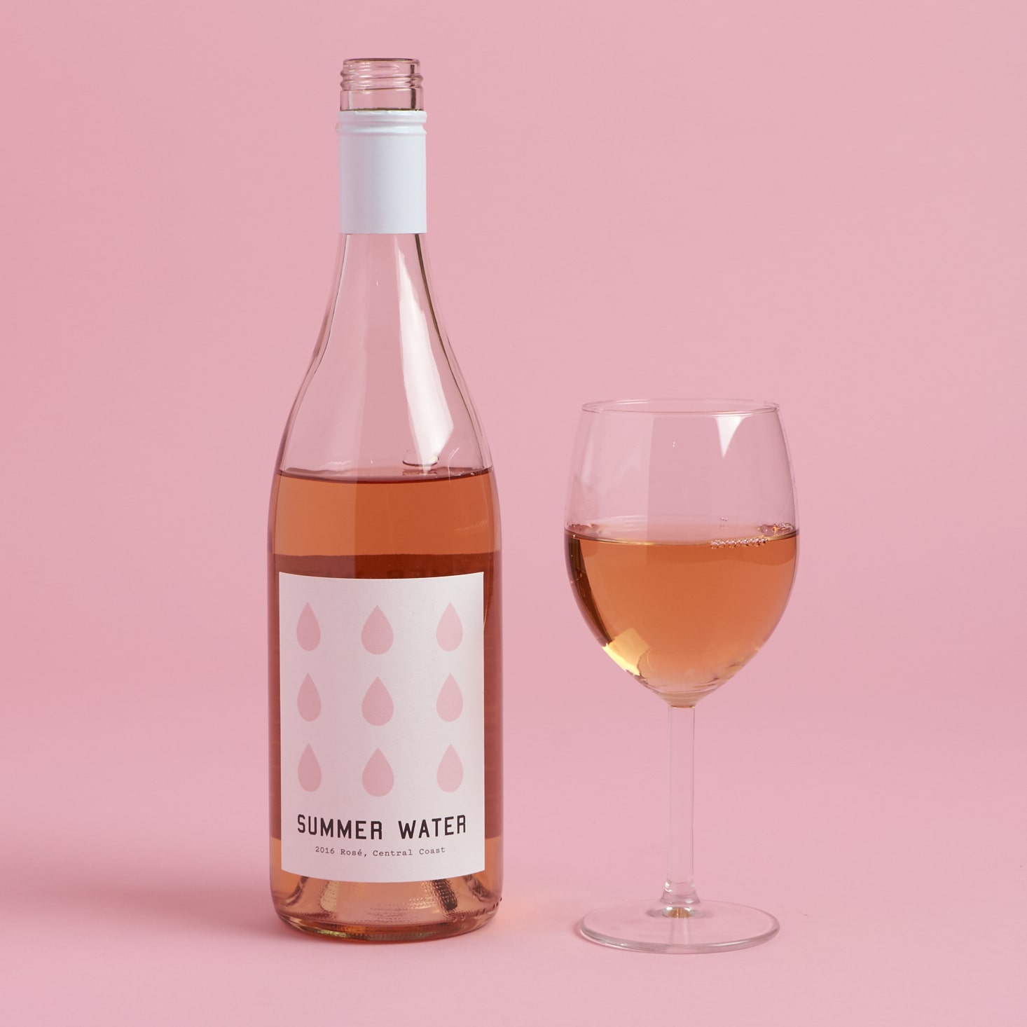 open bottle of summer water rose with filled glass