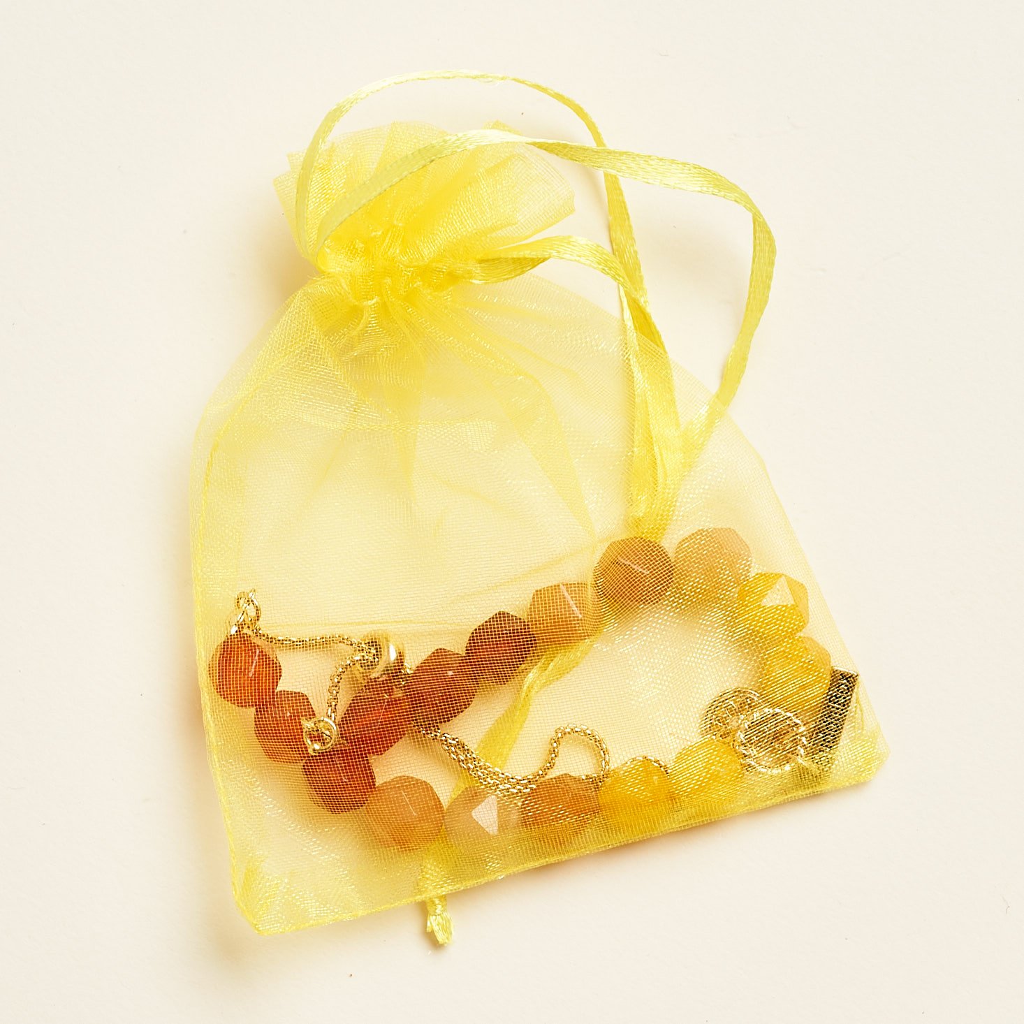 yellow drawstring pouch with bracelet inside