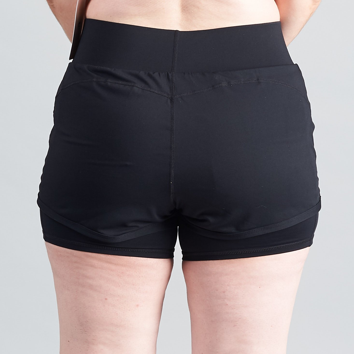 running shorts from behind, showing the leggings-like lining and swishy overlay