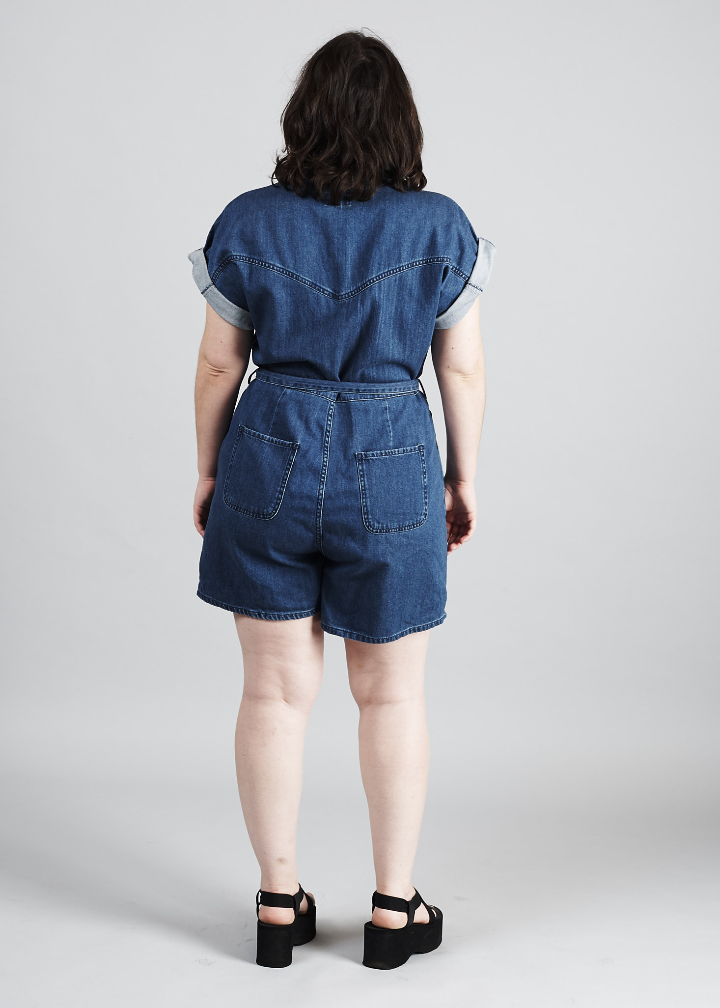 me, from behind, wearing my denim romper, which fits loosely on my back and butt