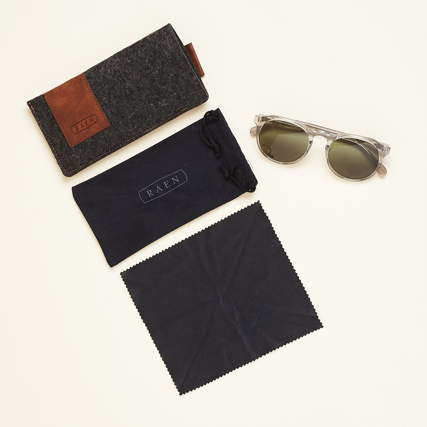 raen sunglasses photographed with inclided felt case and black microfiber case