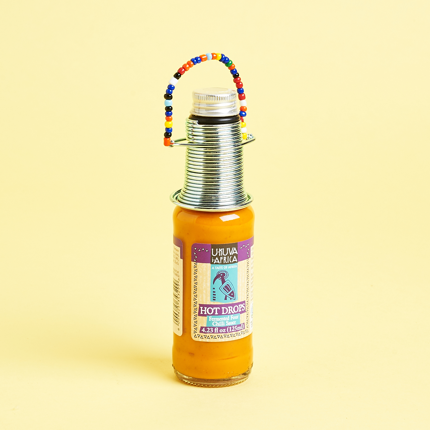 hot sauce with decorative neck coiling and multicolored beads