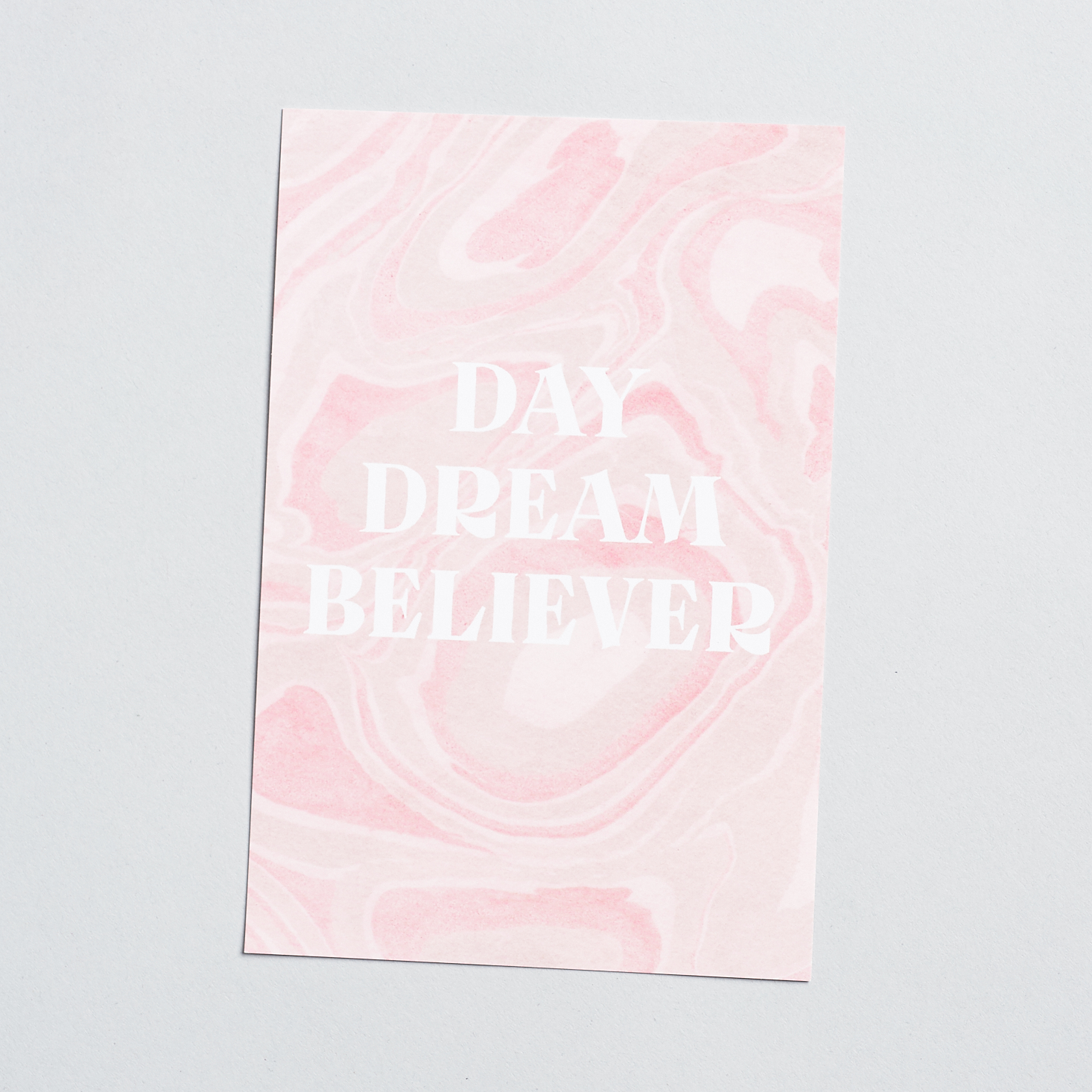 Front of info card with marbled design that says "Day Dream Believer"