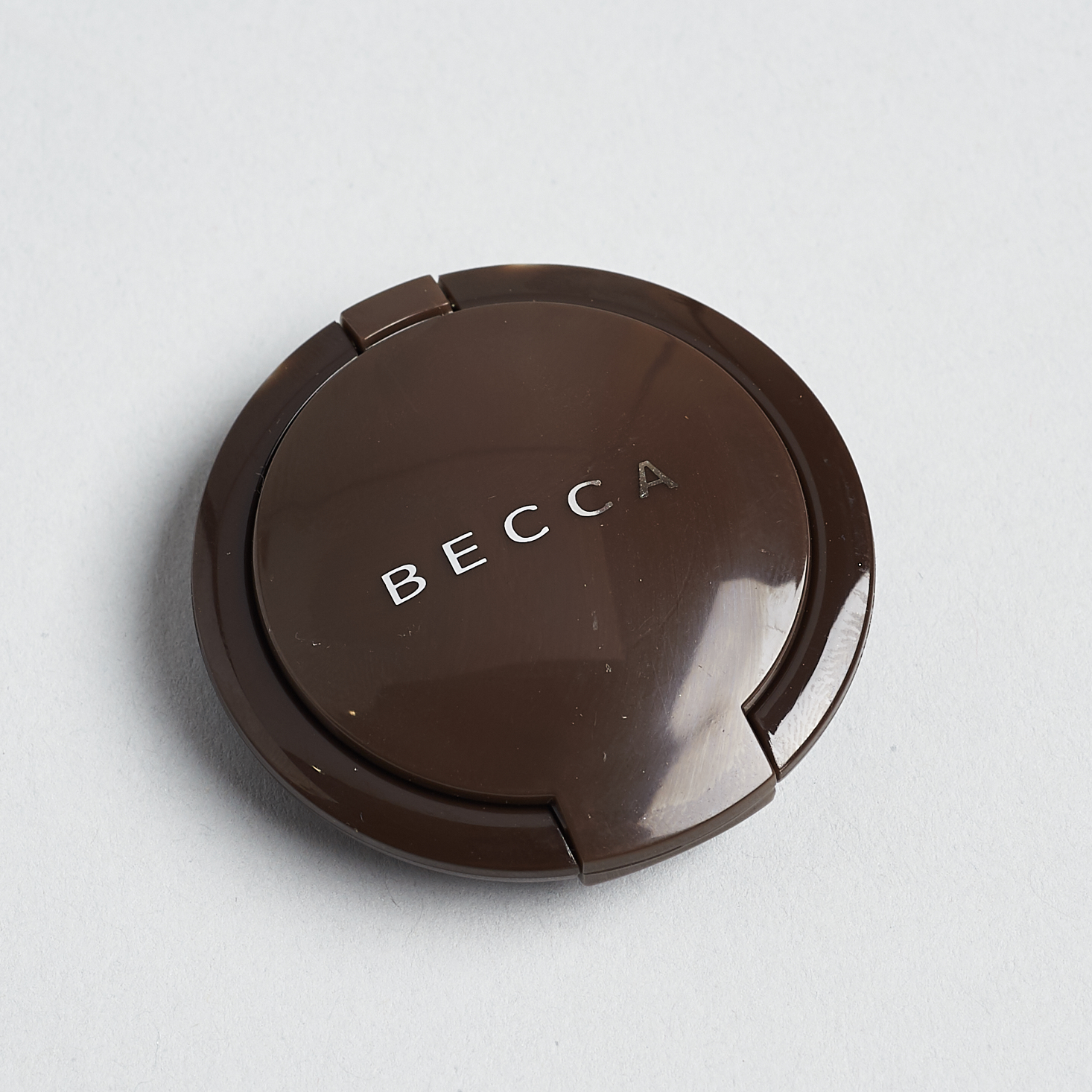 round brown mini powder compact with becca branding