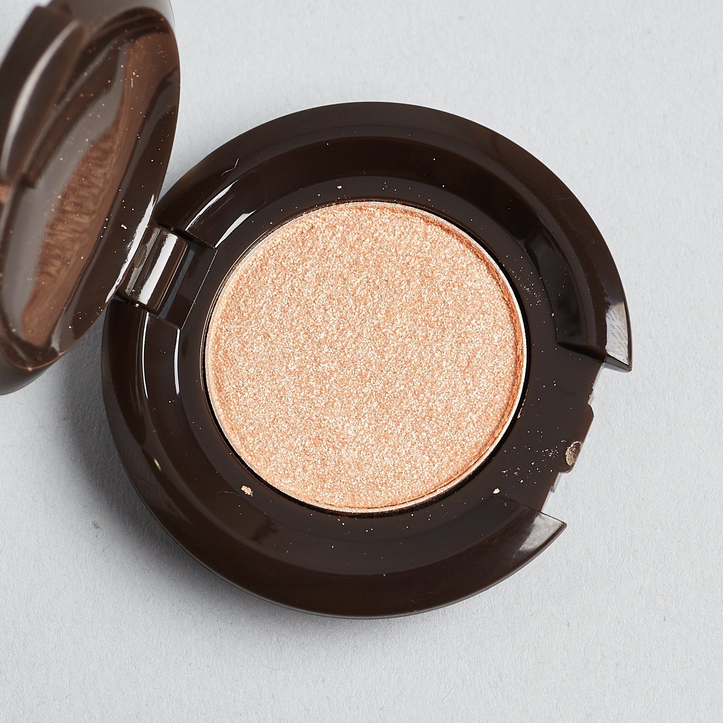 open compact with pale gold powder