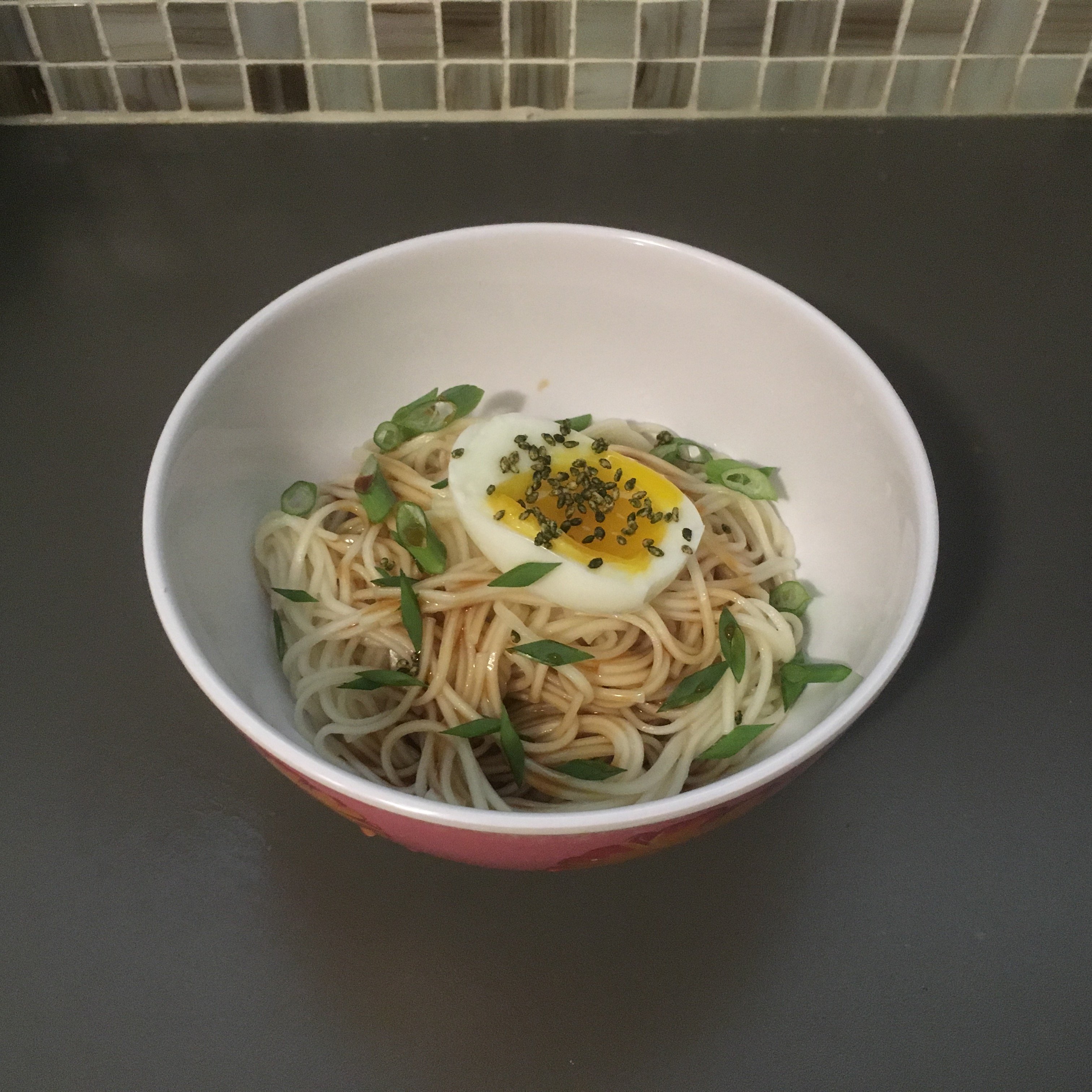 udon pictured with kamatama soy sauce, an egg, and green onions