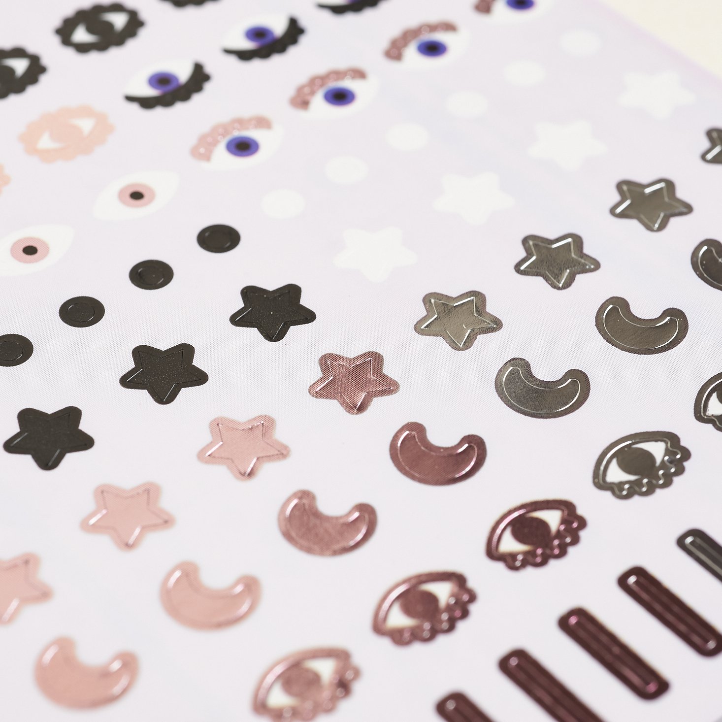 detail of the nail stickers featuring eyes, moons, stars, dots, and metallic stripes