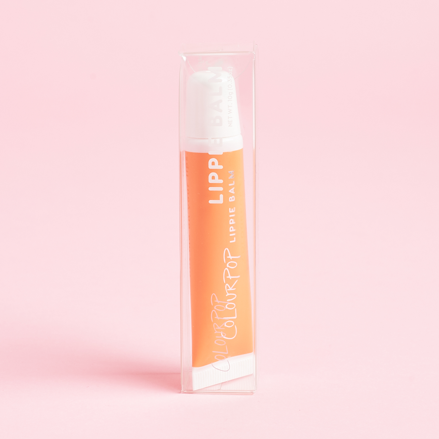 orange tube of lip gloss inside clear box