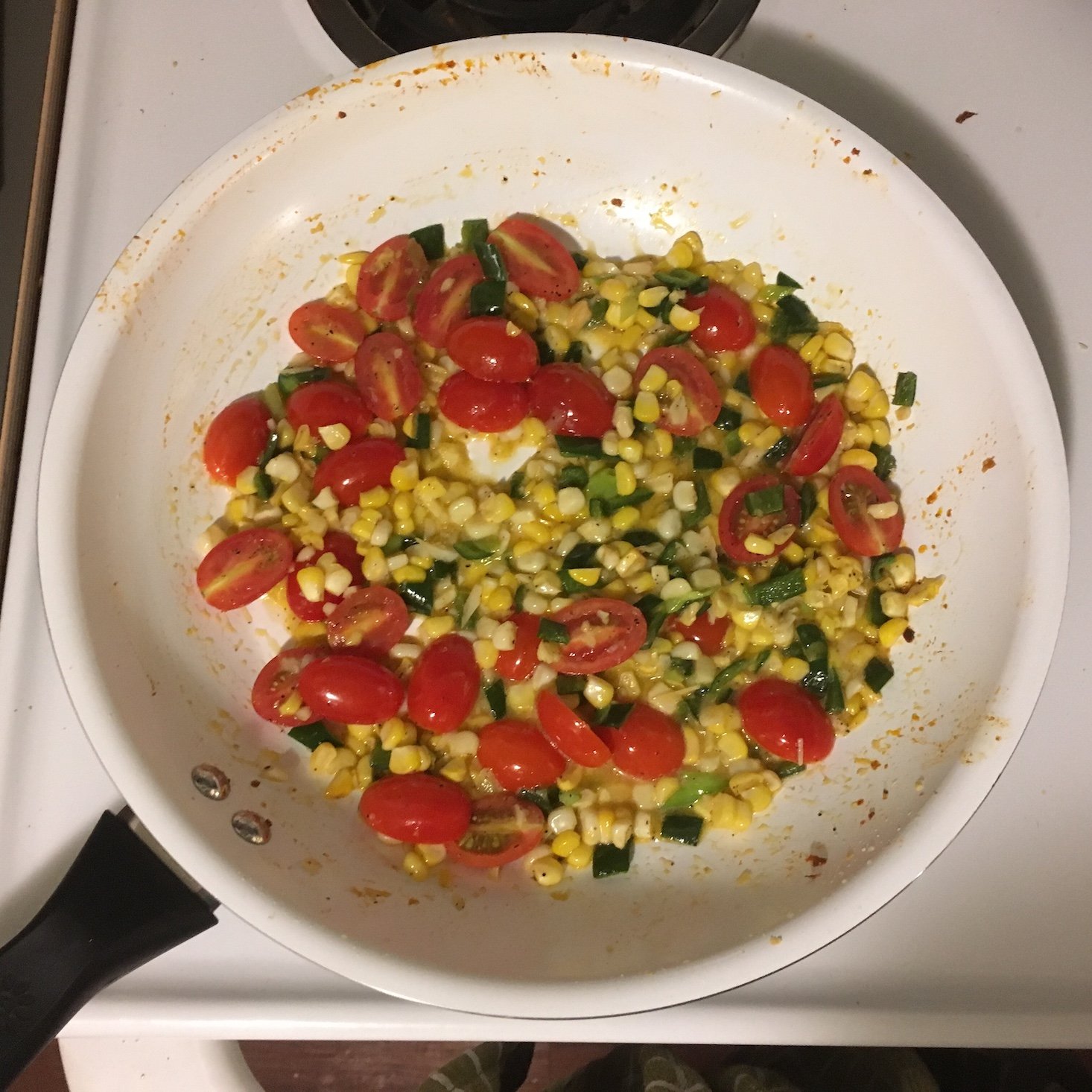 cajun shrimp and corn pancakes tomatoes, corn, green onions, and diced pepper in the pan