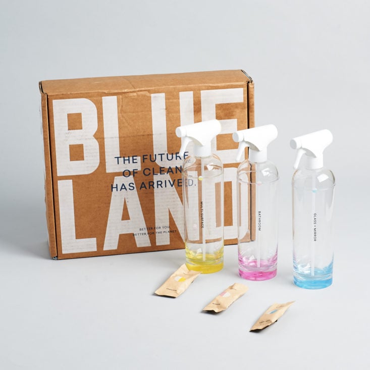 Three different colored bottles and tablets surrounding Blueland box