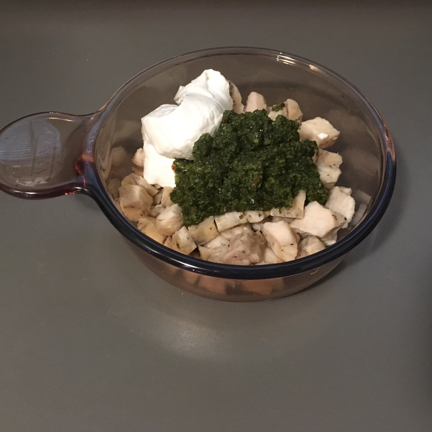 heated chicken in a bowl before stirring in the chimichurri and sour cream