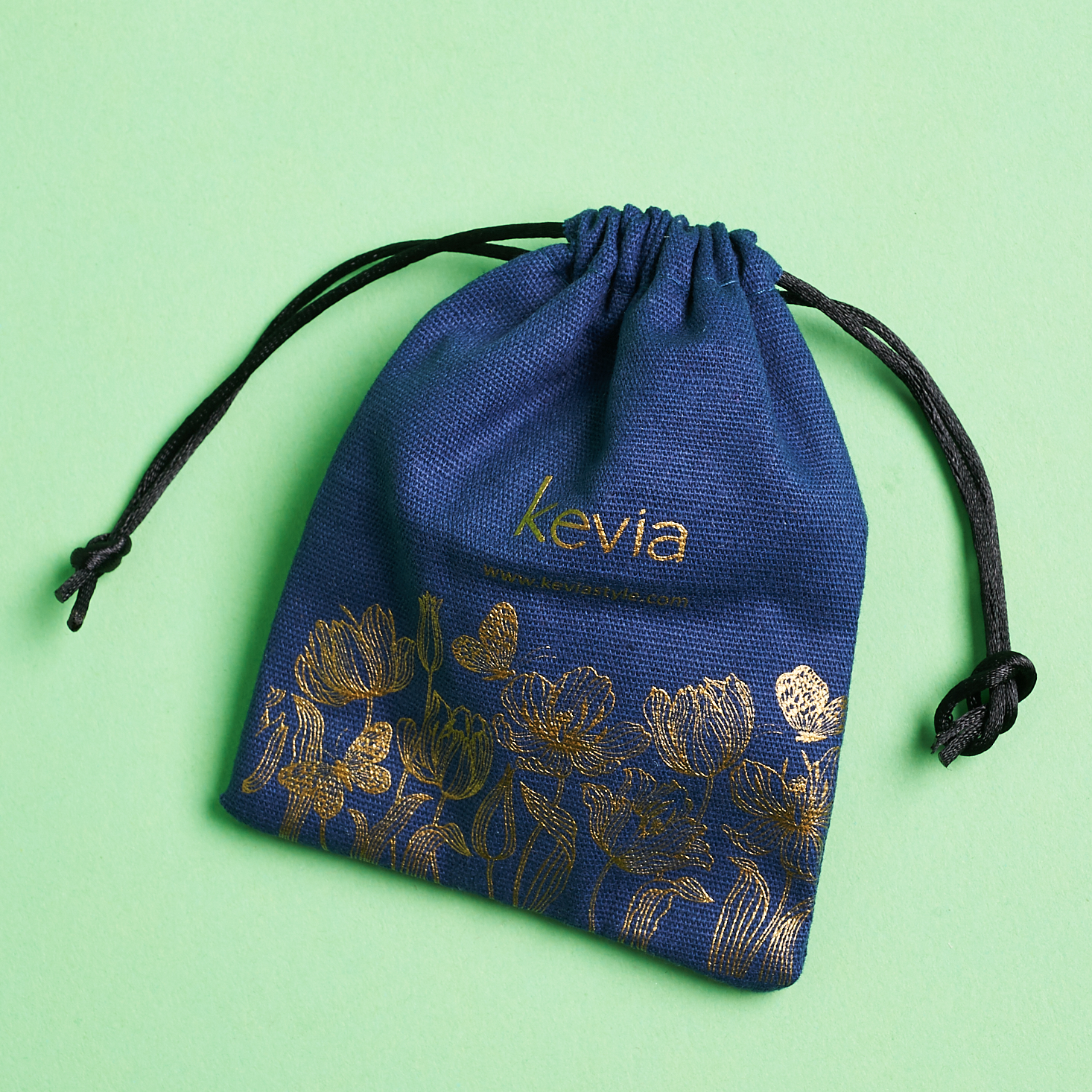 branded navy pouch with gold illustrations