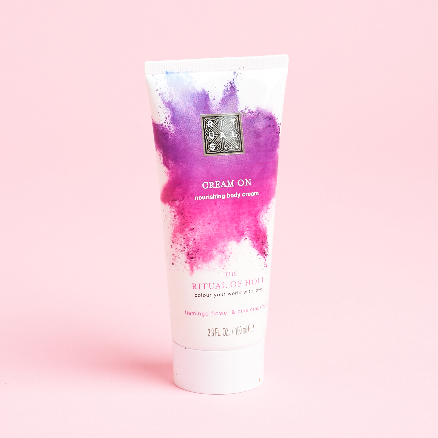 white tube of lotion with bright pink powder explosion graphic