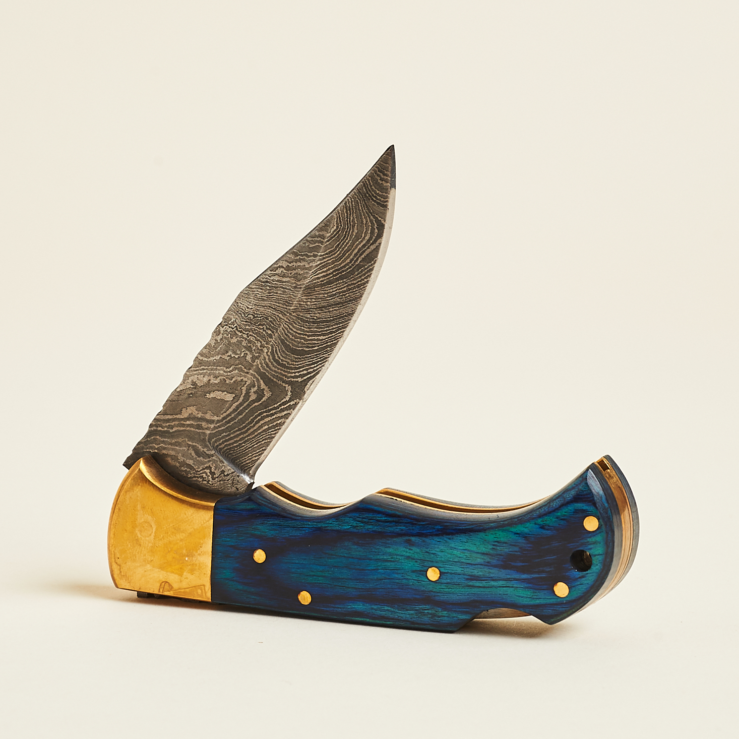 damascus steel knife with blue wood handle and brass accents