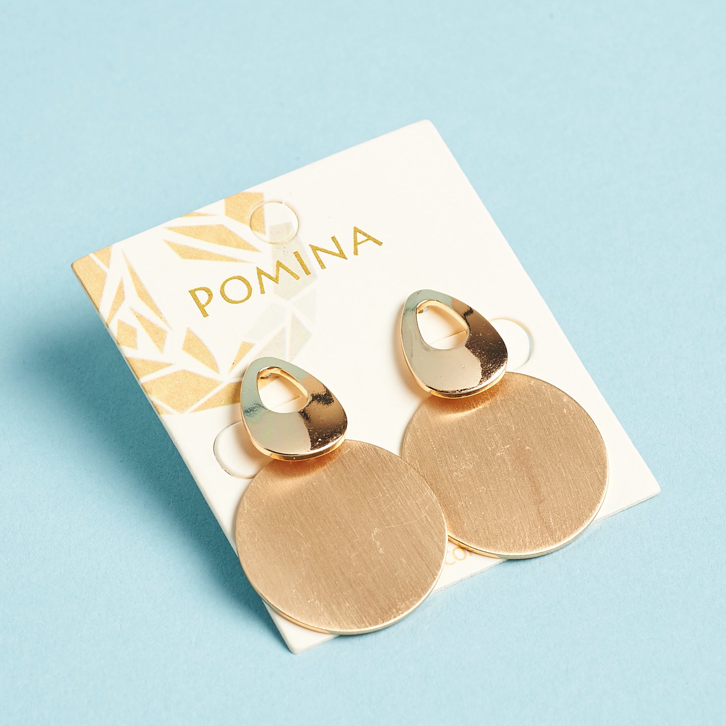 gold colored geometric earrings on card