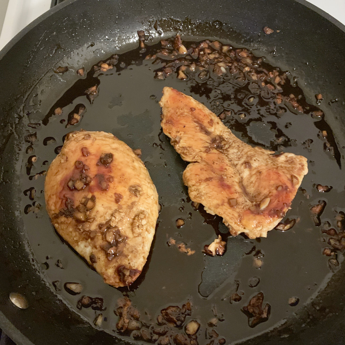 Chicken breasts on pan with sauce