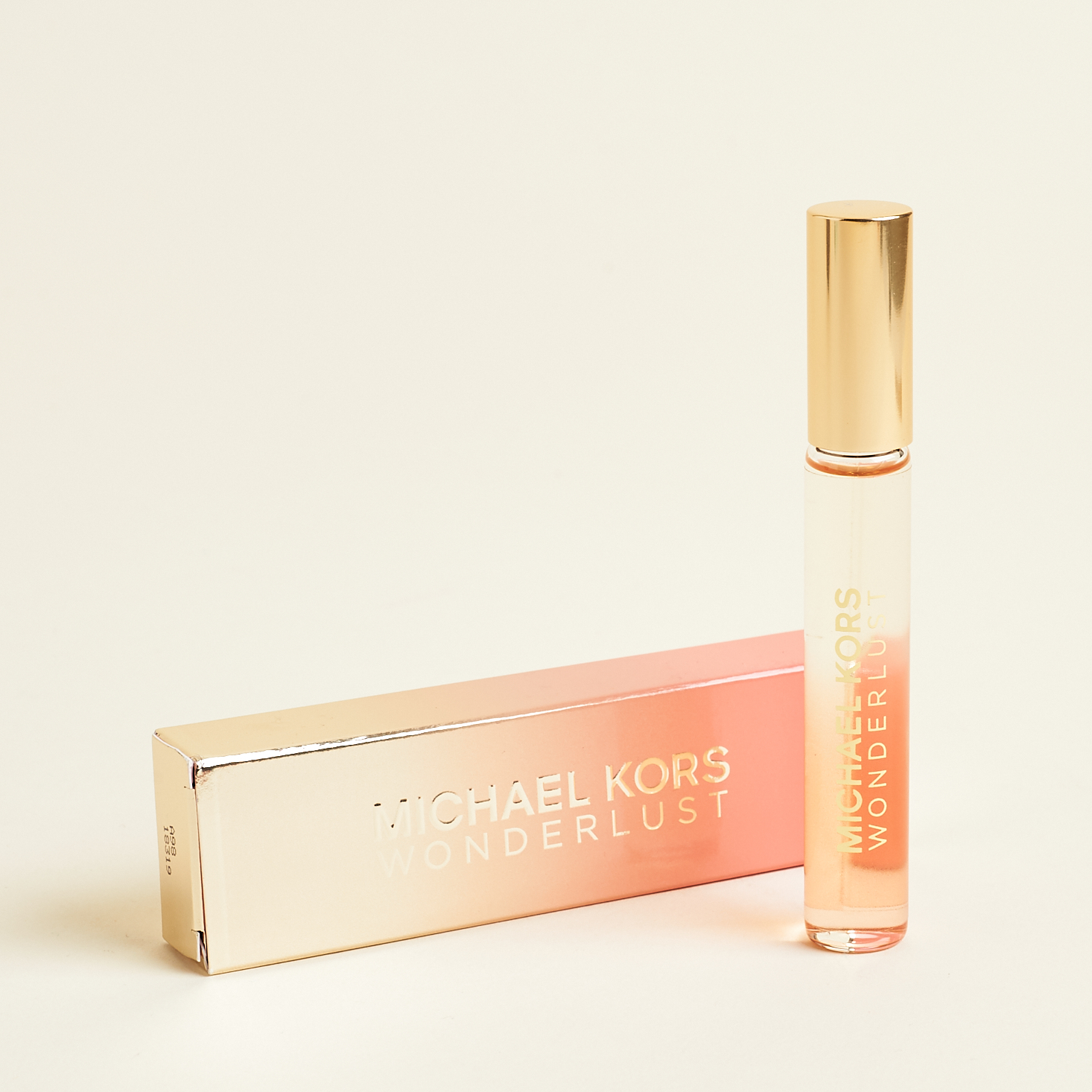rollerball of perfume against pink and gold ombre box