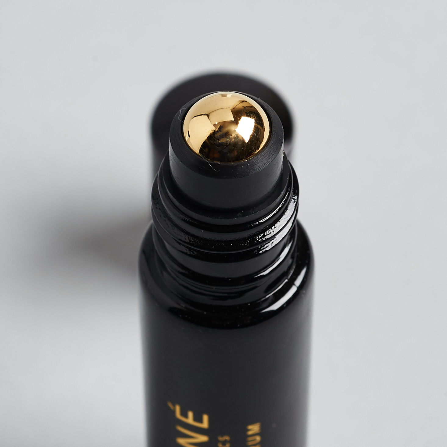 close up of gold roller ball for Henne Organics Lip Serum with box