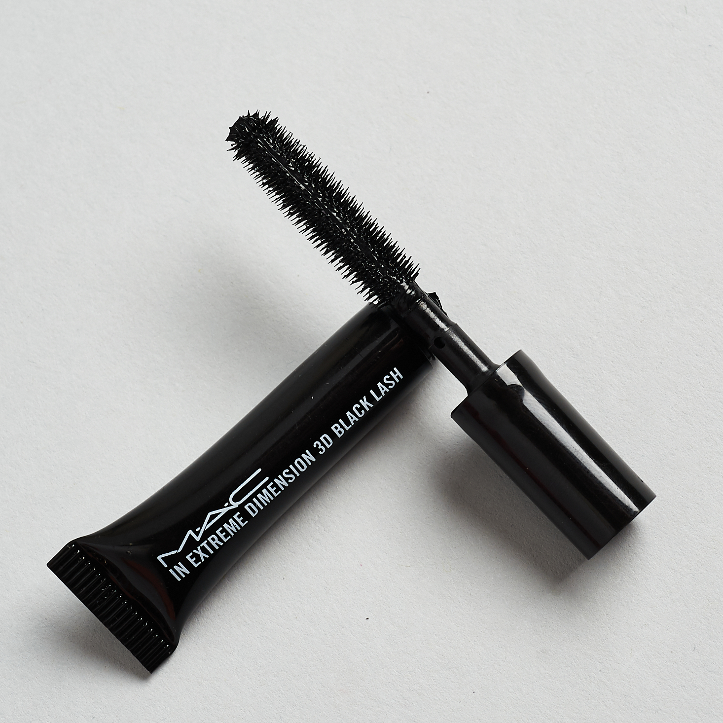 opened MAC Cosmetics In Extreme Dimension 3D Black Lash Mascara with wand resting on tube