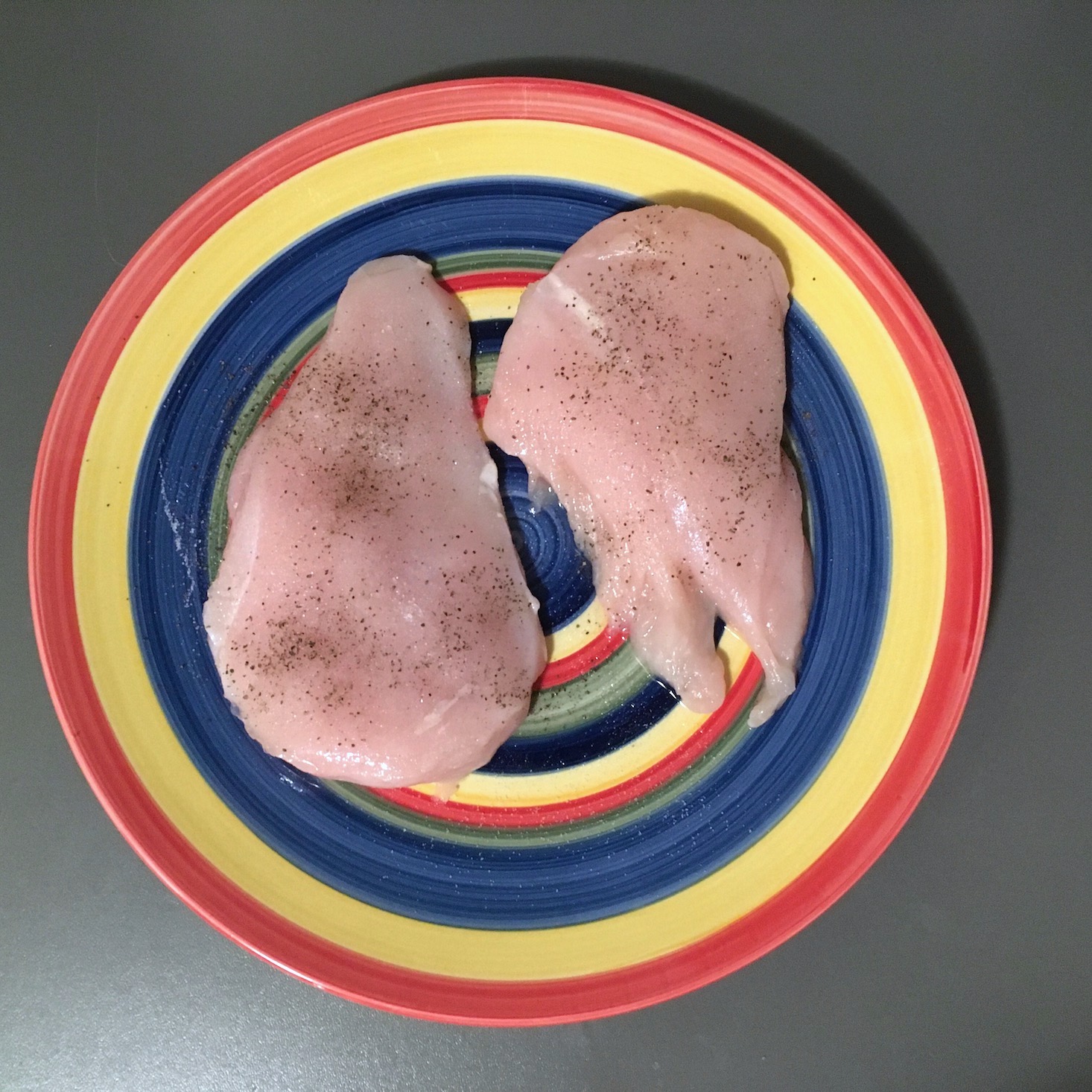 chicken raw and seasoned on a plate