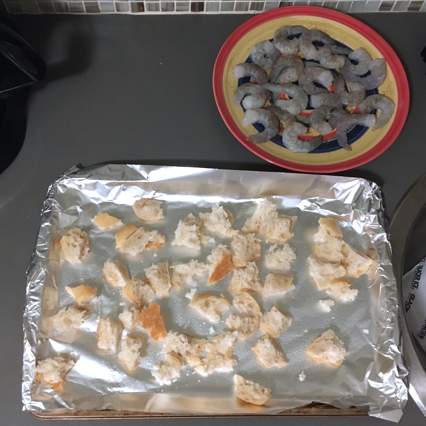 croutons on a tray with raw shrimp on a plate to the side