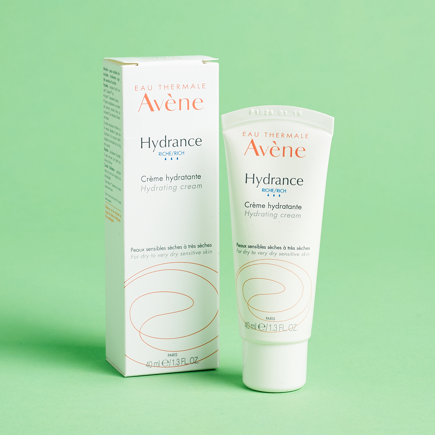 white tube of face cream with peach logo