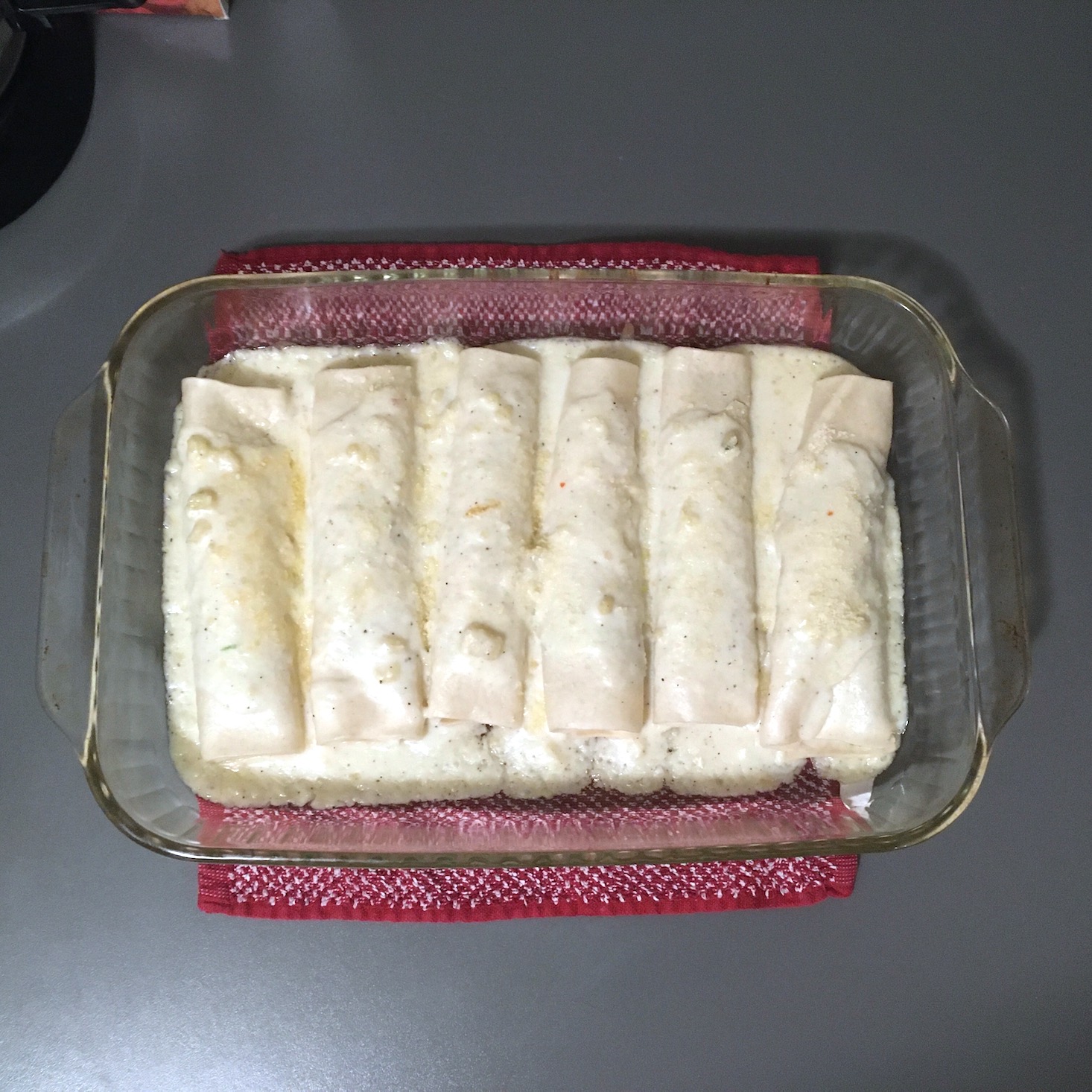 brussels sprouts canneloni covered with cheese sauce in baking dish