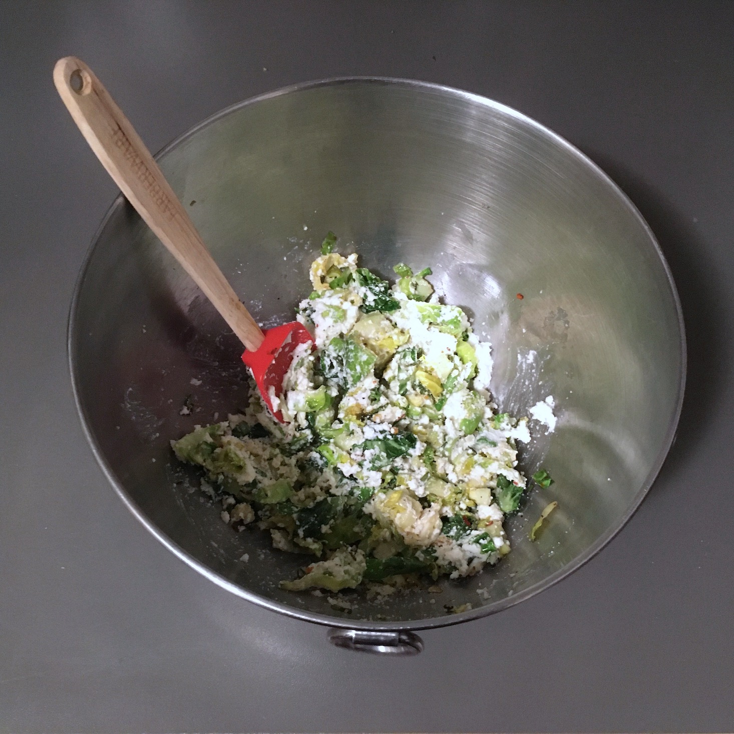 sprouts mixed with ricotta in a mixing bowl