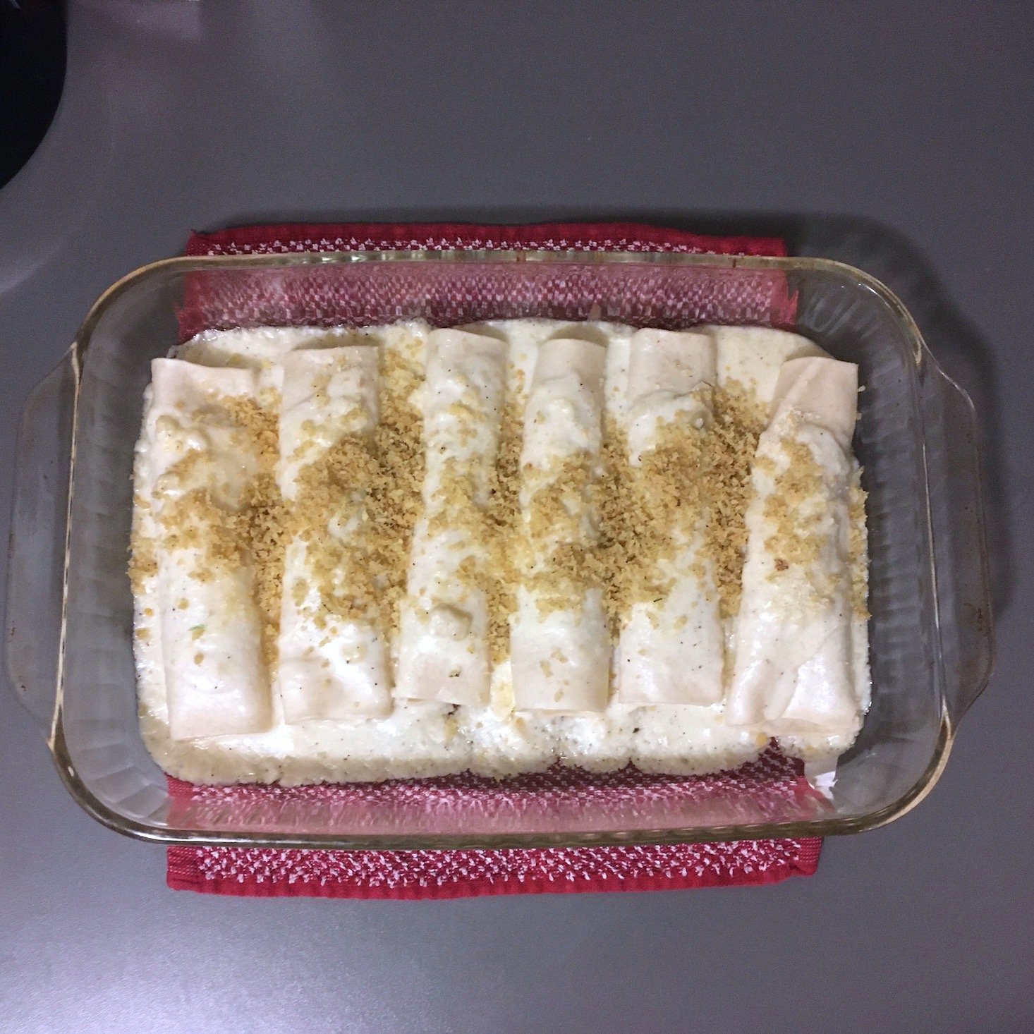 brussels sprouts canneloni topped with breadcrumbs in baking dish