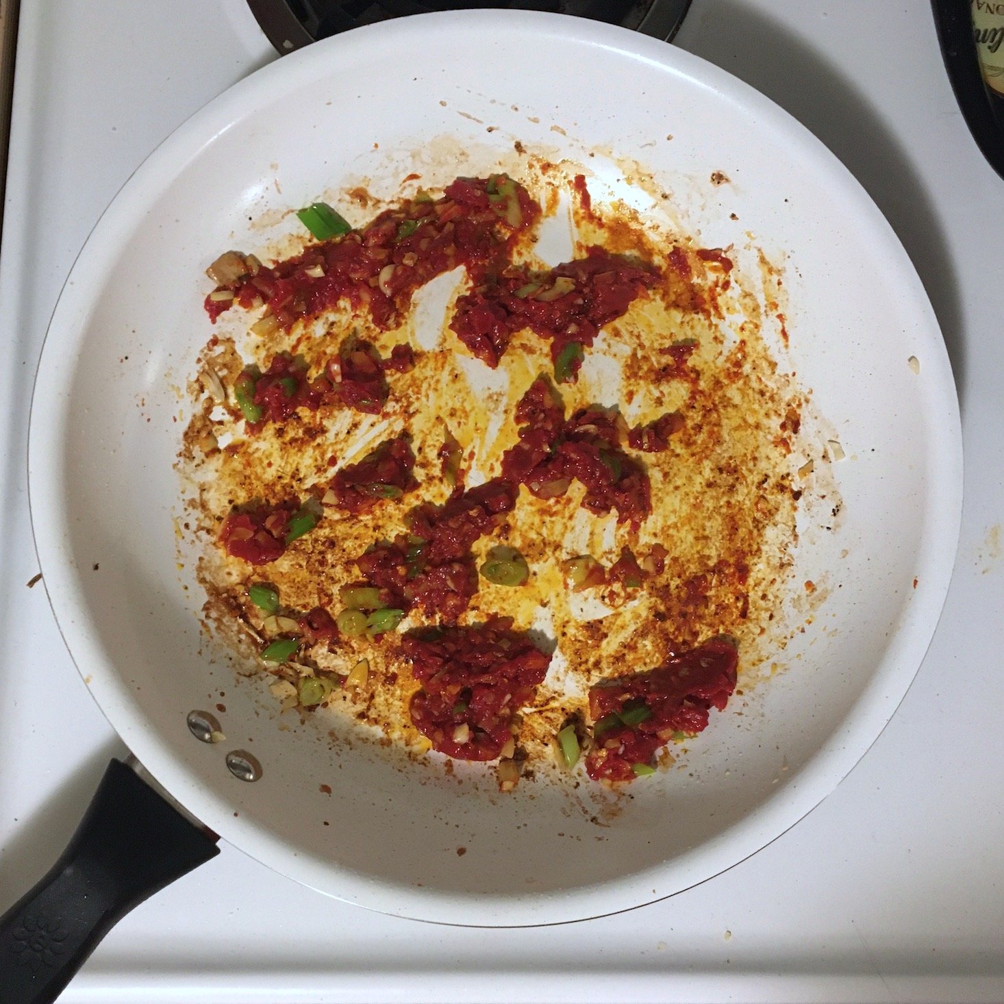 aromatics and tomato paste in pan