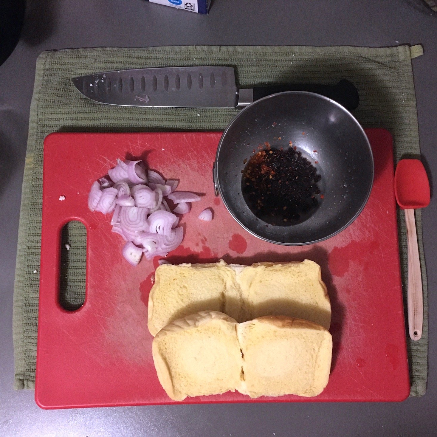 beyond burger ingredient prep showing sliced buns, shallots, and sauce on cutting board