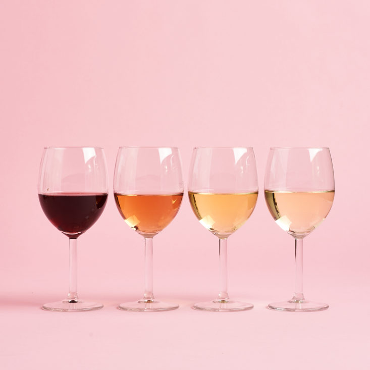 four glasses poured with wine