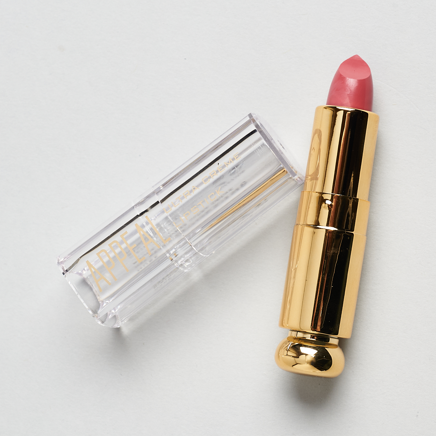 gold lipstick bullet with clear cap and pink lipstick