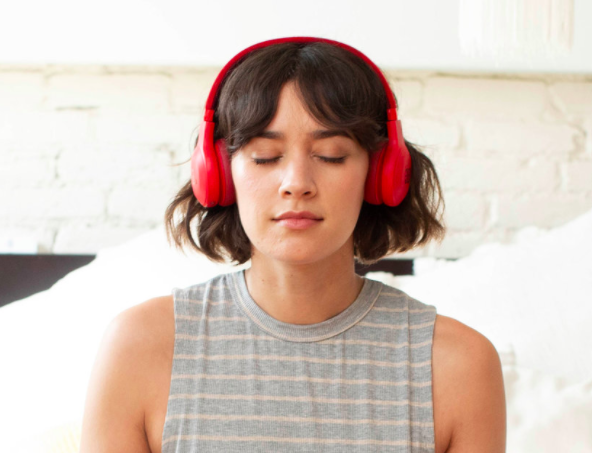 Girl meditating with headphones on using the 10% Happier app.