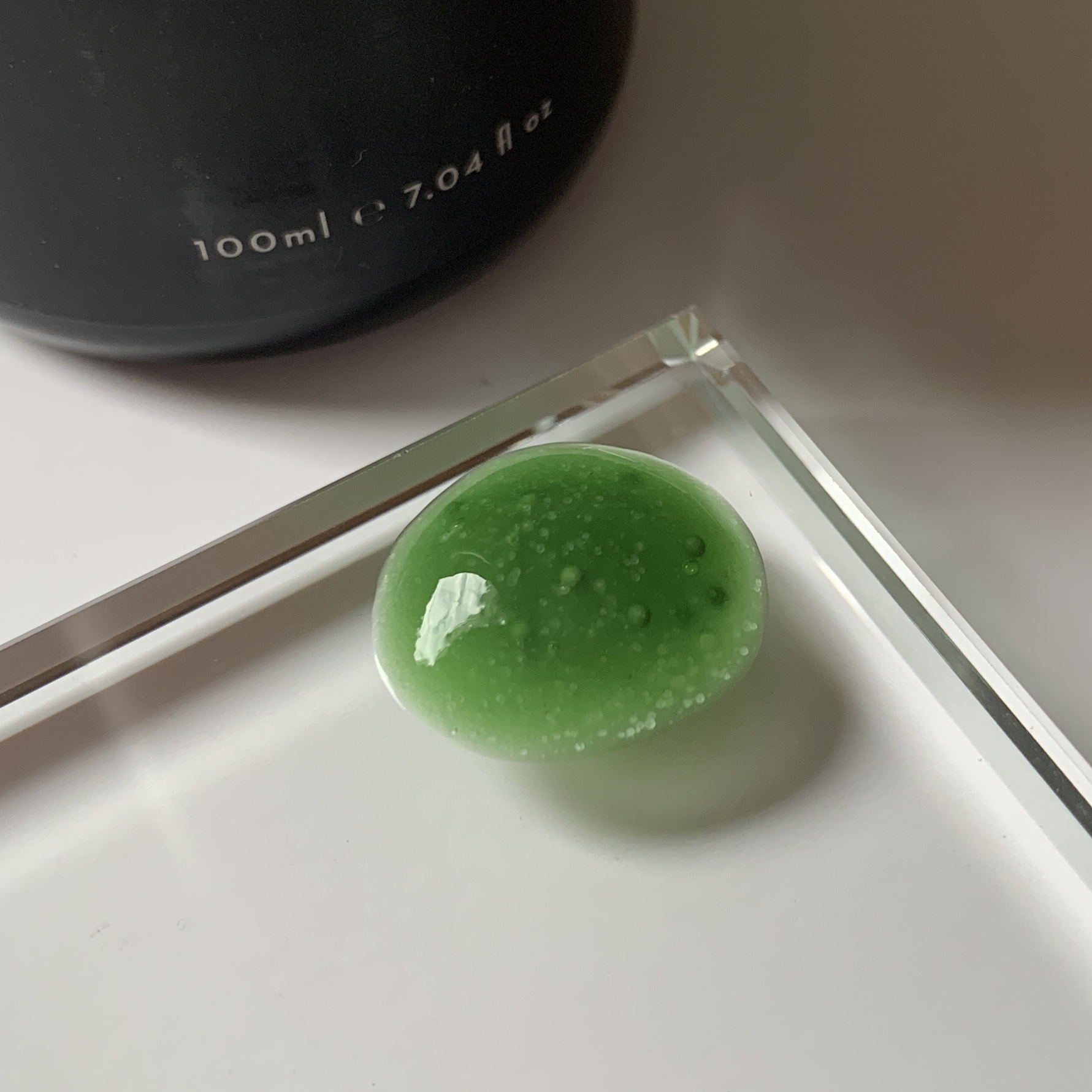 swatch of Mukti Organics 2 in 1 Resurfacing Exfoliant on glass