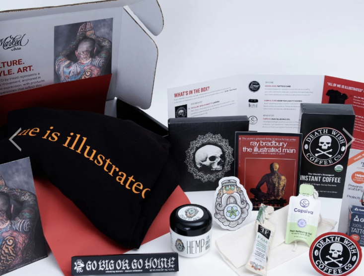 a collection of items in a box from the Marked By Ink Everyday Hero Edition.