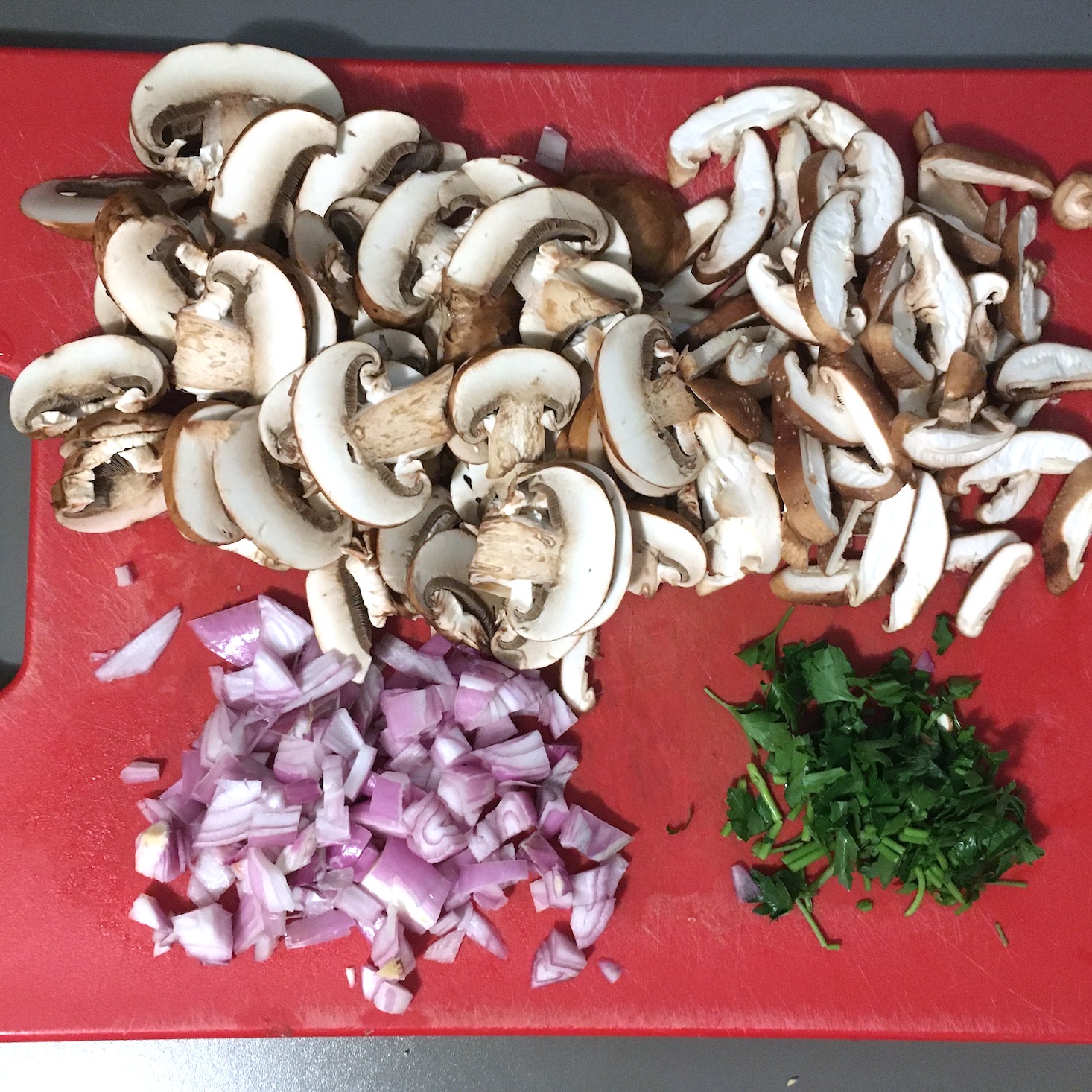 mushroom risotto chopped veggies on red cutting board