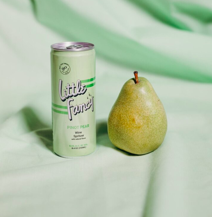 Can of Little Fancy positioned next to a pear.
