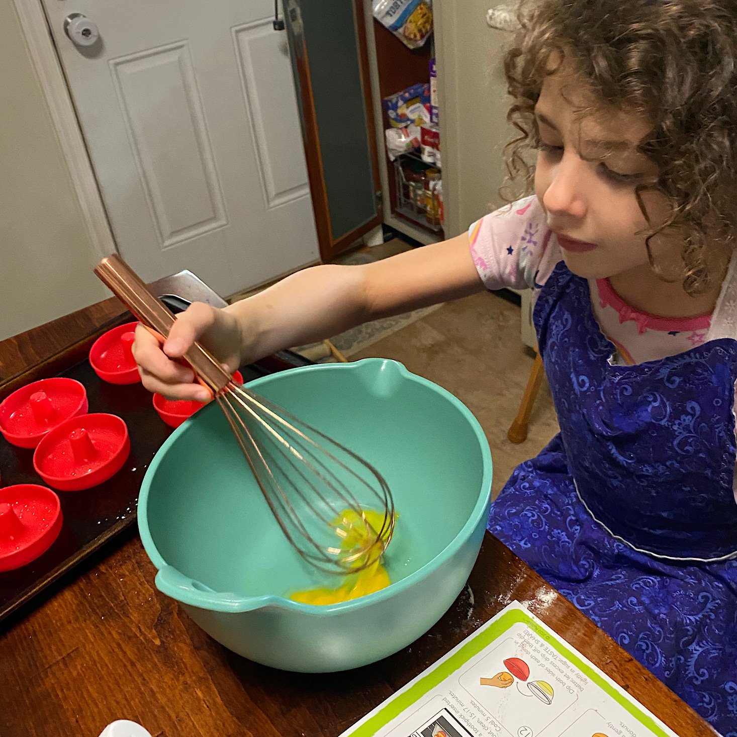 Girl whisking egg in bowl