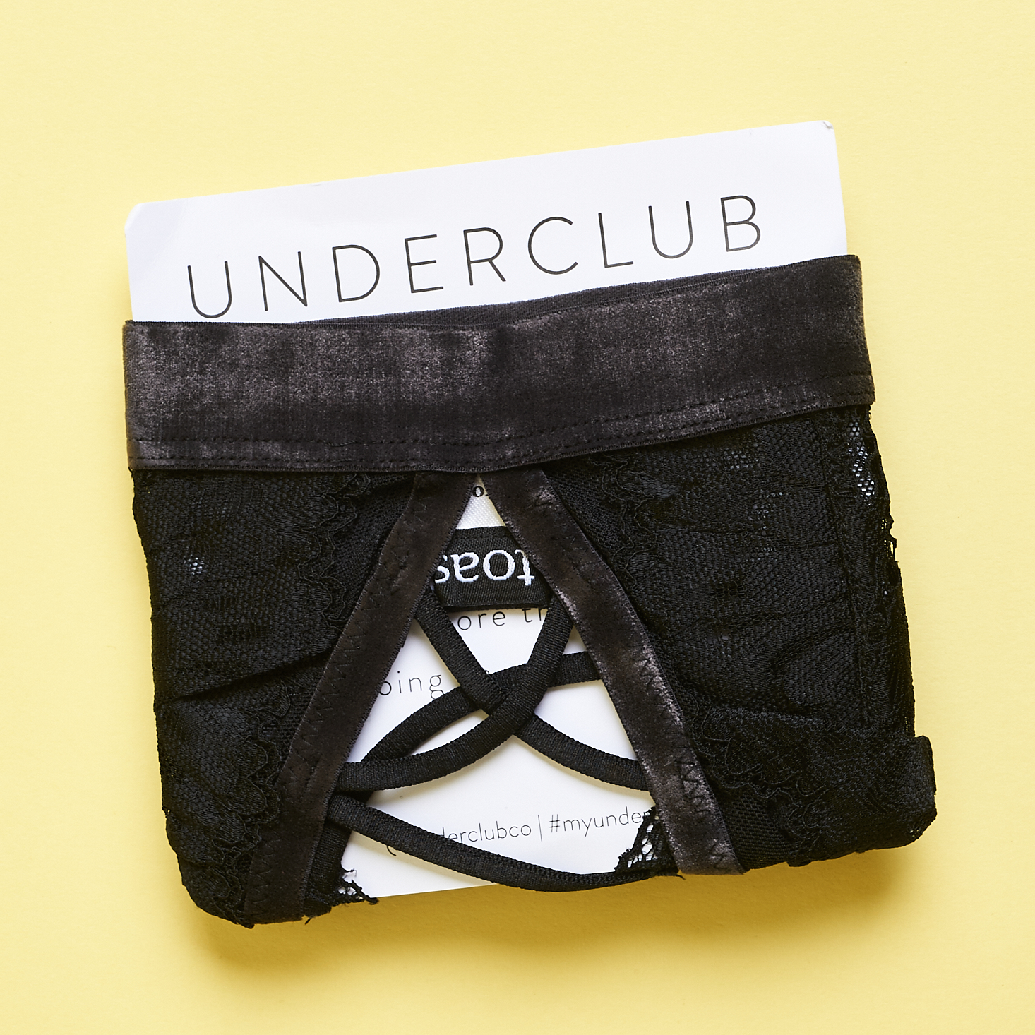 Underclub black lace bralette wrapped around card