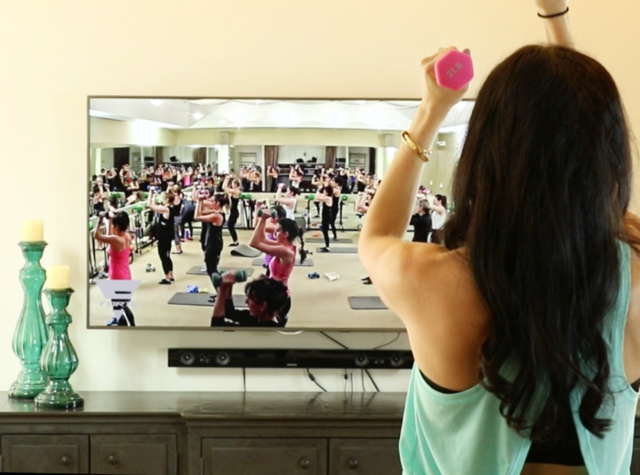 girl working out with weights in front of tv 