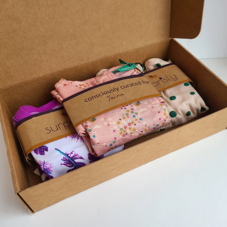 Open Suprisly box, showing three outfits folded in the package