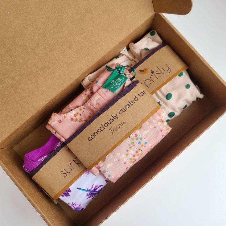 Open Suprisly box, showing three outfits folded in the package