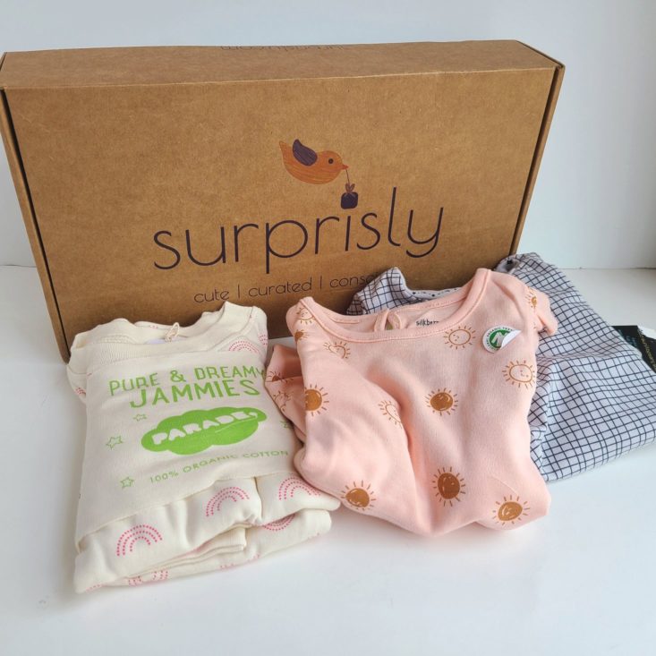 Suprisly May 2021 three outfits folded in front of shipping box