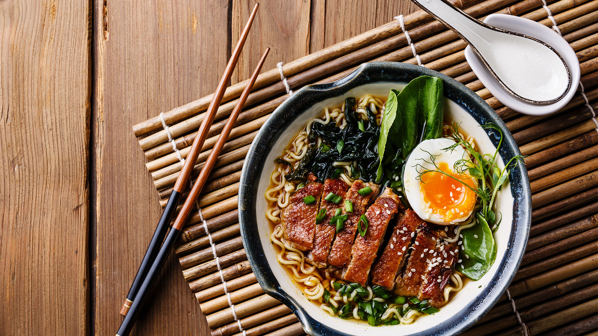 Duck noodles with egg and pak choi cabbage in bowl on wooden background