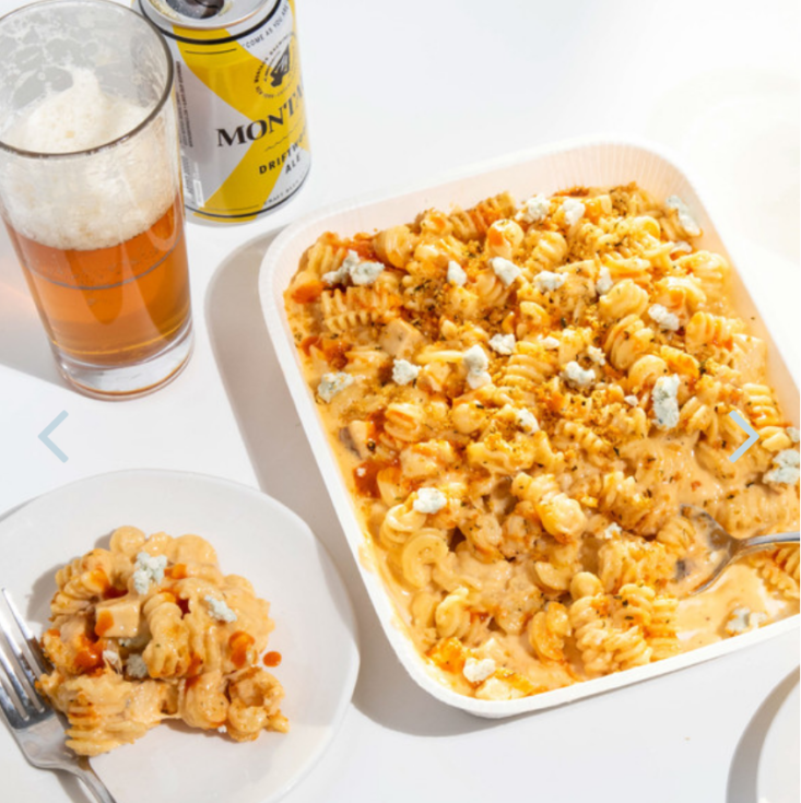 mac and cheese on a plate with mac and cheese platter and can and glass of beer